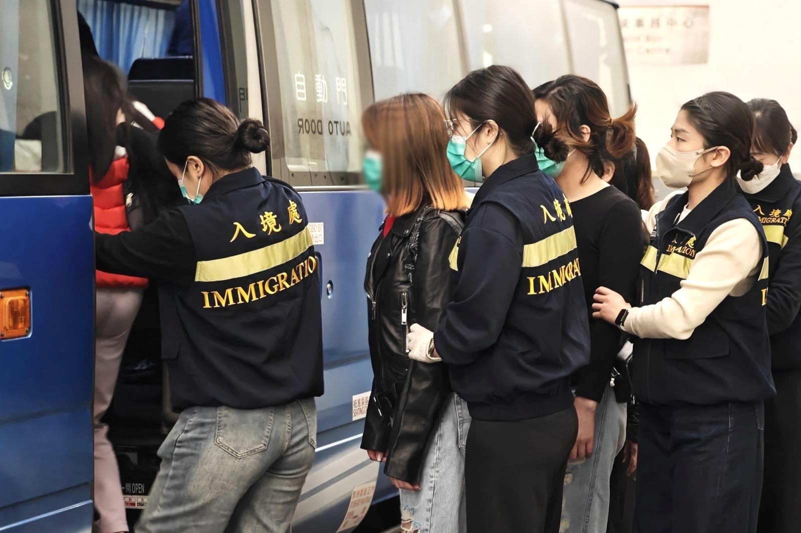 Photo shows removees being escorted by ImmD officers to proceed from the detention place to the airport