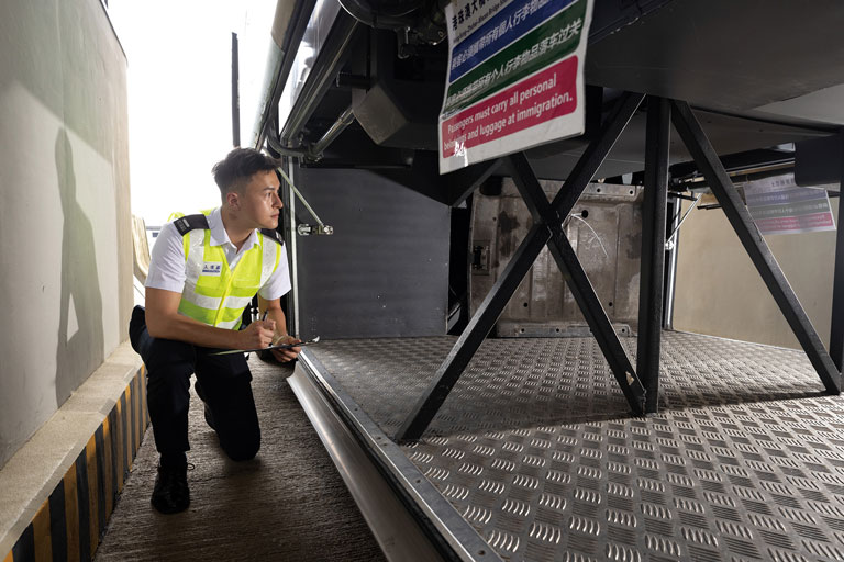 Immigration staff of Hong Kong-Zhuhai-Macao Bridge Control Point inspecting a cross-boundary vehicle.